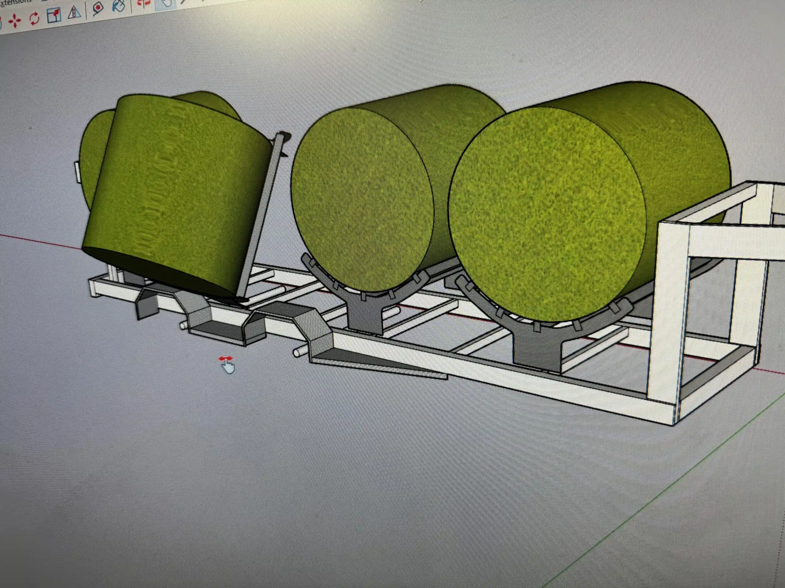 A cad drawing showing green cylinders representing hay bales, positioned on an axis from bottom left to top right, resting on the representation of a mechanical trailer. The trailer is depicted with  gray parallel beams , one along the front and one along the back face of the cylinders. These parallel beams supporting the cylinders terminate with vertical beams connected at the top and bottom with another pair of beams that are parallel to each other at the top and bottom of the vertical beams.  Another pair of beams are attached to the top of the vertical beams and are parallel to each other and to the beams at the base of the structure. The drawing shows semi-cylindrical cradles under each green bale that hinge along the front supporting beam (first mentioned), to tilt the bales at an angle and dump them on a field..
